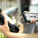 Seseorang memindai barcode pada kemasan produk menggunakan alat scanner di toko