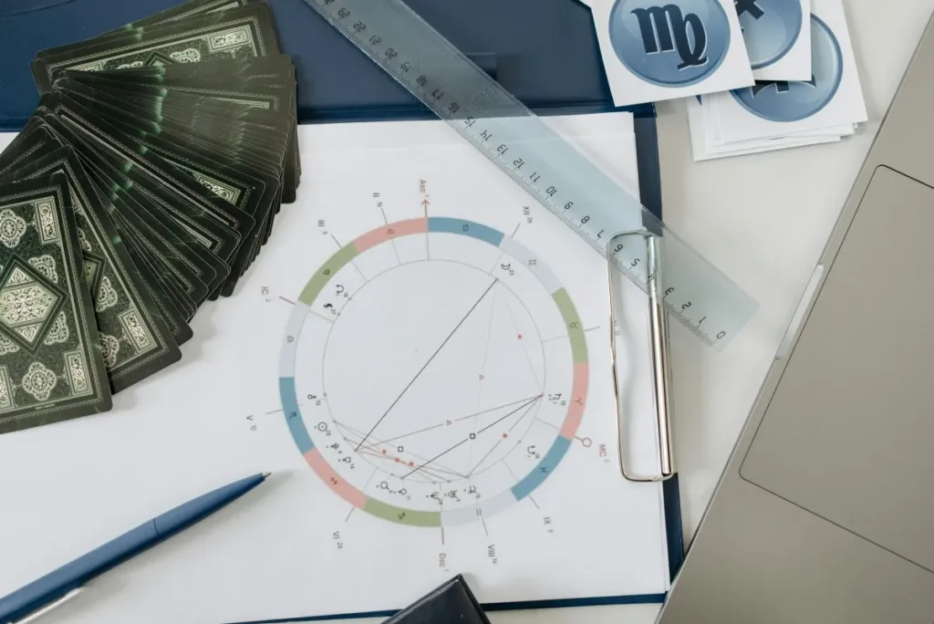 Kartu tarot dan peta natal astrologi di atas meja, cocok untuk tema zodiak dan astrologi