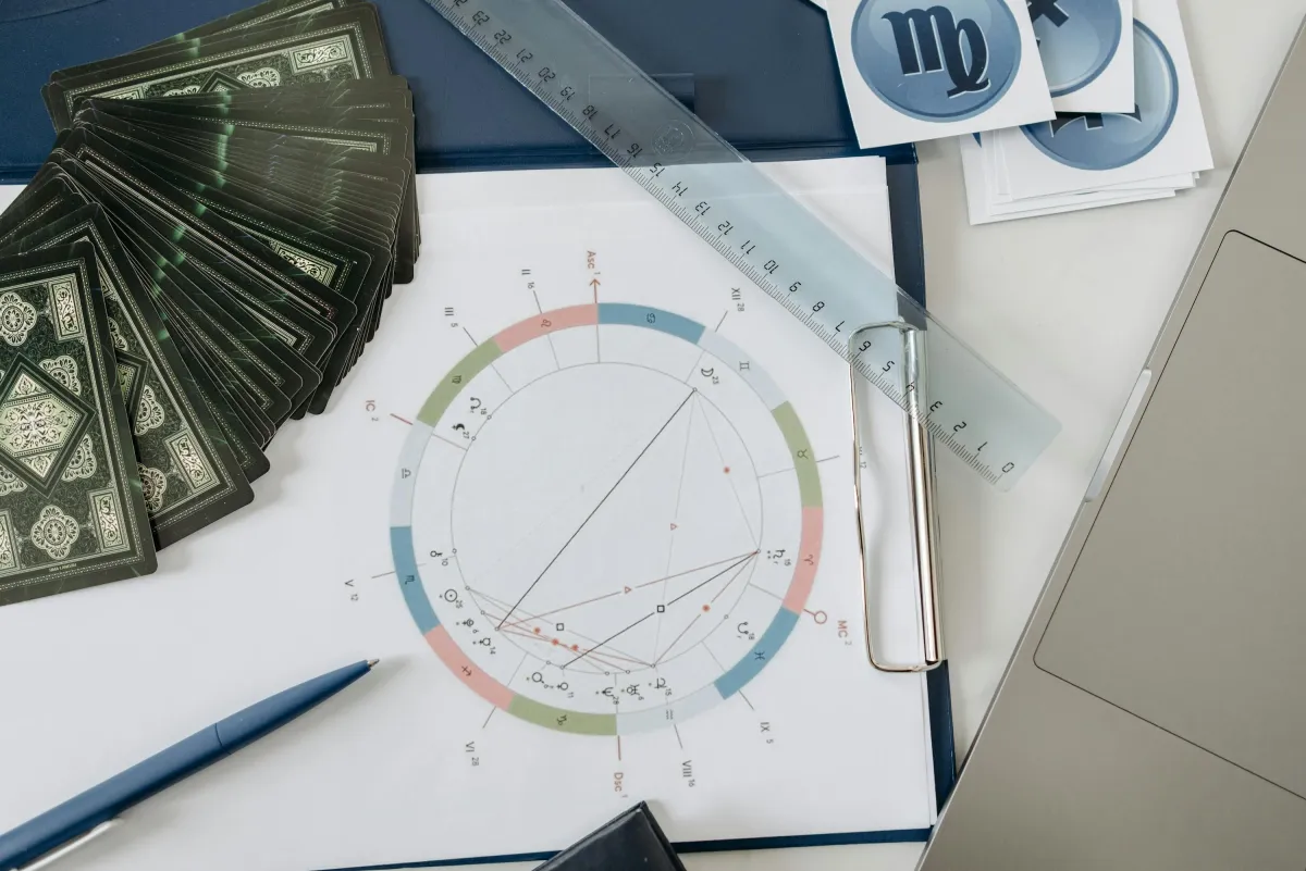 Kartu tarot dan peta natal astrologi di atas meja, cocok untuk tema zodiak dan astrologi